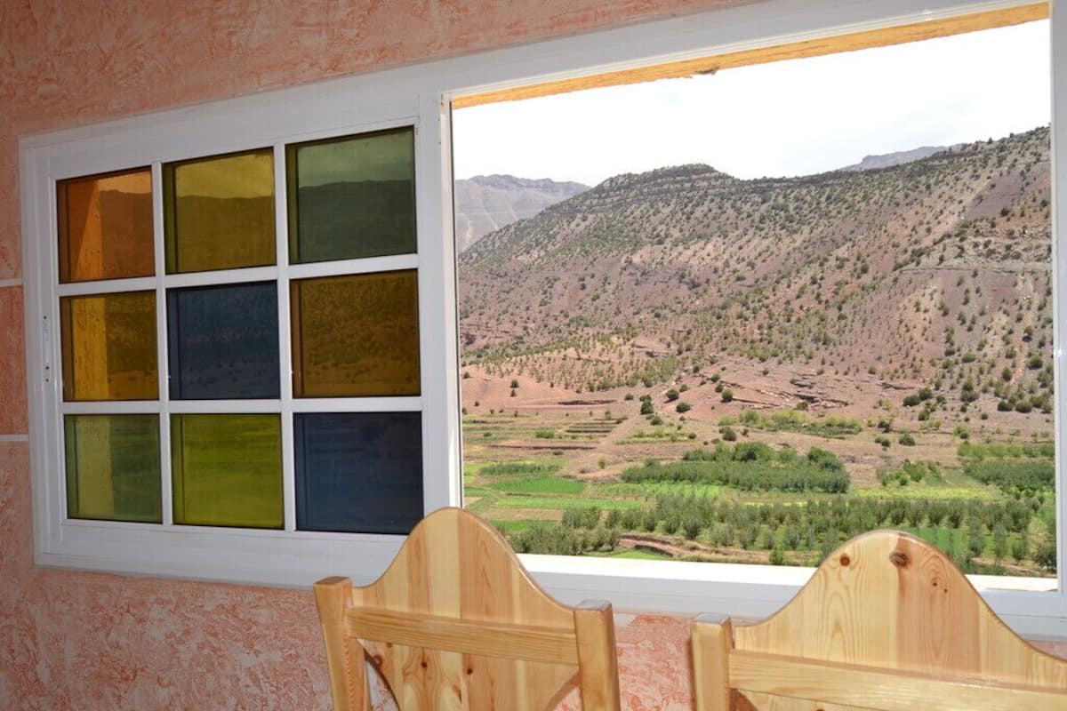 A room with a large window offering a view of a mountainous landscape.