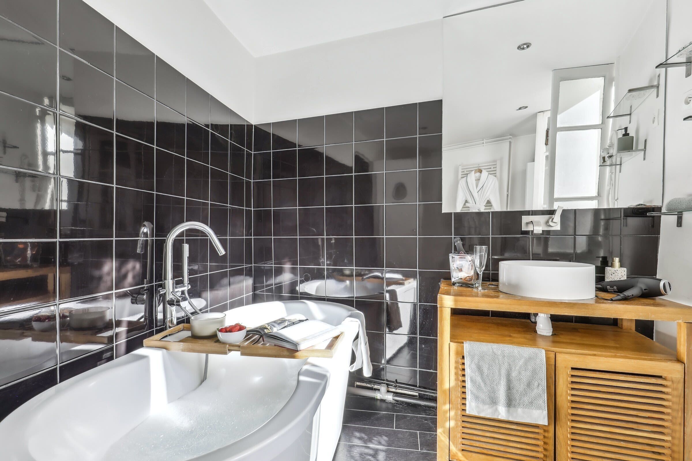 Une salle de bain moderne avec une grande baignoire, un lavabo et un meuble-lavabo avec un miroir.