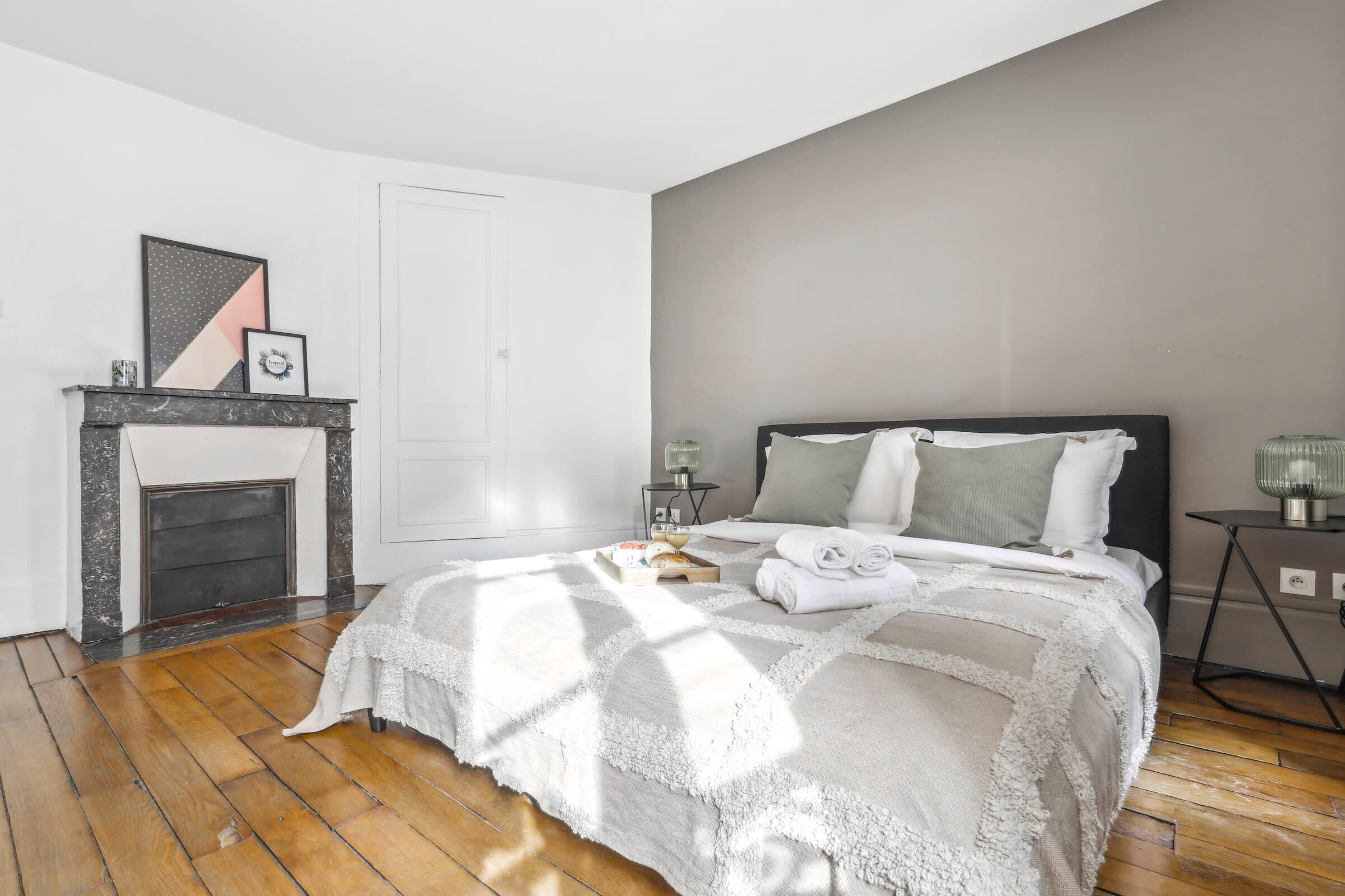 Une chambre à coucher avec un lit, une cheminée et une table de chevet.