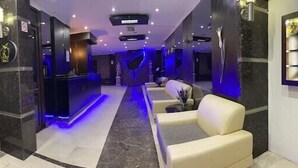 A modern hotel lobby with a reception desk, seating area, and a wall-mounted plant display. - KOLİBRY SV HOTEL (Konyaalti)