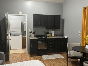 Modern kitchen with oven and stove, central island, and dining area.