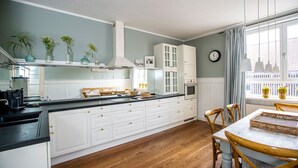 A kitchen with white cabinets, a black countertop, and a dining area with a table and chairs.
