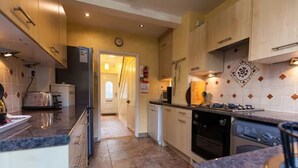 A kitchen with a stove, oven, dishwasher, and a refrigerator. - Oak House (Machynlleth)