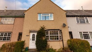 A two-story residential building with a central entrance, a bay window on the first floor, and a satellite dish on the right side. - Oak House (Machynlleth)