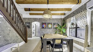 A modern dining area with a wooden table, black chairs, and a woven pendant light. - Casa Alaïa | West Brickell | Sleeps 20 | Pool&Spa (Miami)