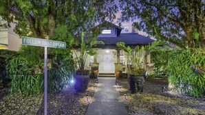 A house with a pathway leading to the entrance, surrounded by lush greenery and potted plants. - Casa Alaïa | West Brickell | Sleeps 20 | Pool&Spa (Miami)