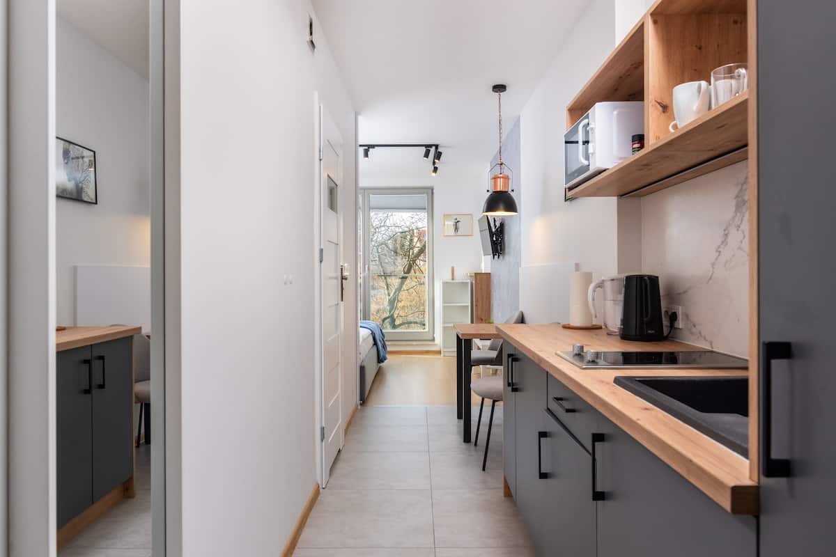 A modern kitchen with a wooden countertop, a built-in sink, and a pendant light.