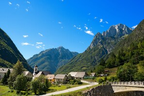 Un village de montagne avec des maisons traditionnelles, une église et un pont en pierre.