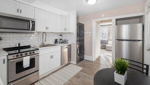 A modern kitchen with white cabinetry, stainless steel appliances, and a central island.