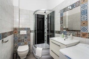 11B. Studio Kalwaryjska | Badkamer | Een douche, een haardroger, handdoeken, zeep