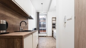 A modern kitchen with wooden countertops, a black faucet, and a built-in oven. - Kalwaryjska Apartments (Kraków)