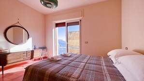 Un dormitorio con una cama grande, un aparador, un espejo y una ventana con vistas.