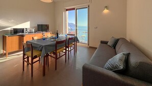 Un espacio habitable moderno con comedor, sofá y cocina.