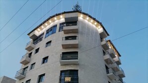 A multi-story building with balconies, large windows, and a corner design.
