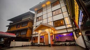 Un hotel de varios pisos con entrada cubierta e interior bien iluminado.
