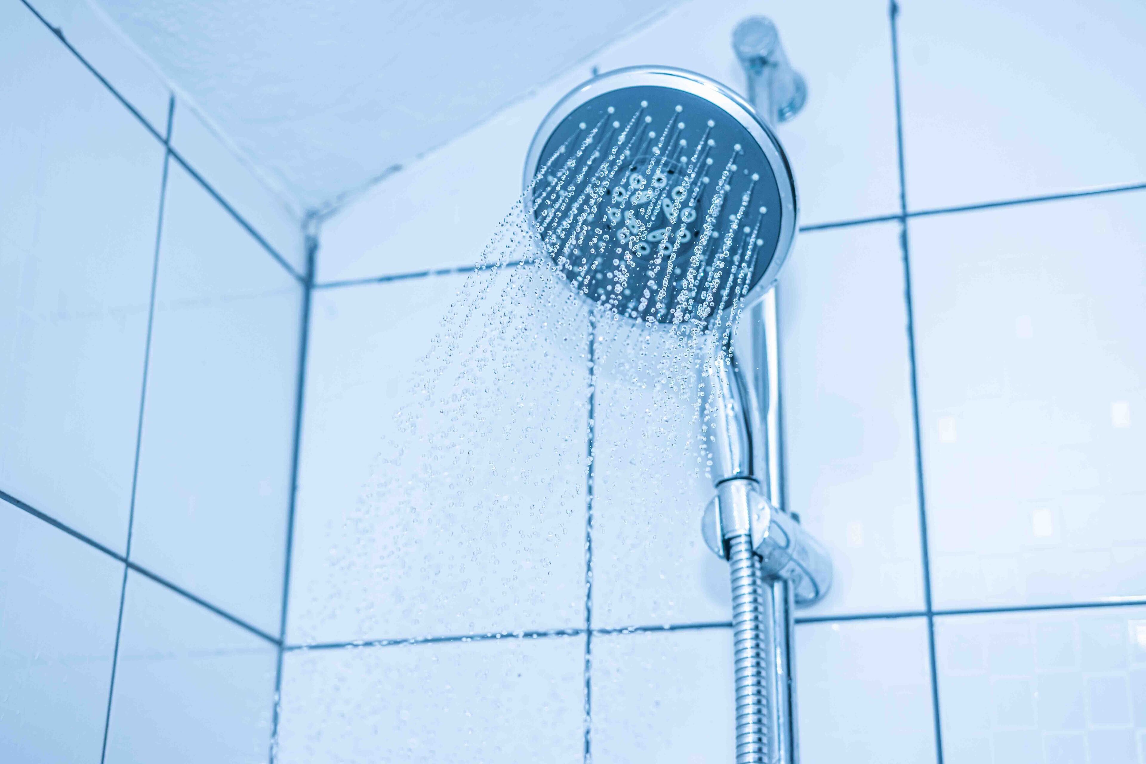 Un pommeau de douche d'où jaillit de l'eau.