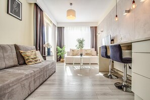 A modern living room with a sofa, a coffee table, and two bar stools.