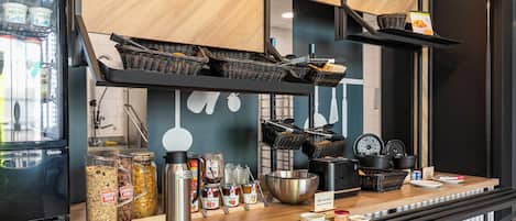 A breakfast bar with various food items, a coffee machine, and baskets.