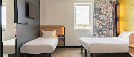 Habitación de hotel con dos camas individuales, un espejo grande, un televisor de pantalla plana, un ventanal con vistas y un cabecero de madera.