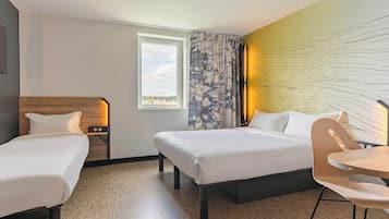 Une chambre d’hôtel avec deux lits, une tête de lit en bois, une fenêtre avec vue, une table avec une chaise et un mur avec un luminaire.