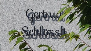 A textured wall with the words "Gernung" and "Schloss" in a decorative font. - Gertrud Schlössli (St. Gallen)