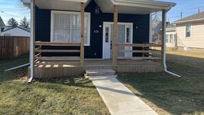 A single-story house with a covered porch, a front door, and a mailbox.