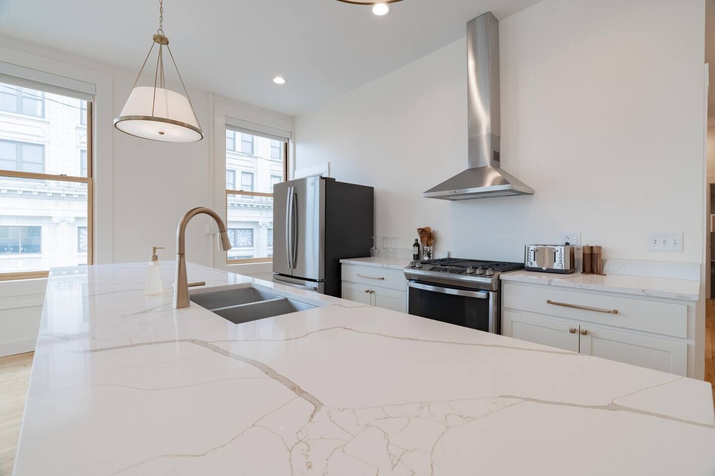 Una cocina moderna con una isla grande, electrodomésticos de acero inoxidable y un diseño elegante.