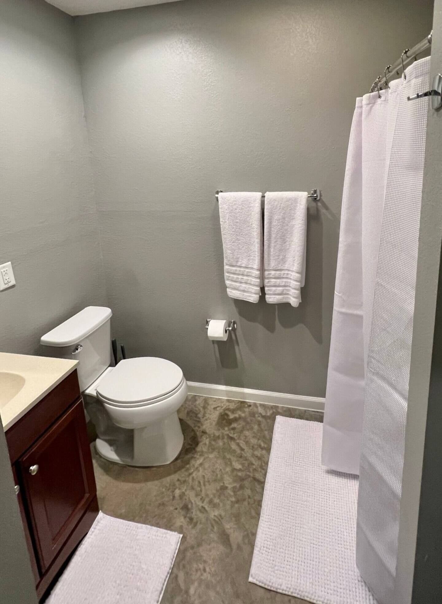 A bathroom with a toilet, sink, and shower curtain.