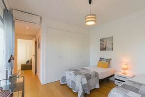 Cozy retreat with a patterned bedspread, bedside table, and wardrobe with mirror.