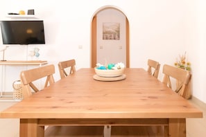 Enjoy meals in this dining area with a long table and six chairs, a flat-screen TV, and a cozy atmosphere.