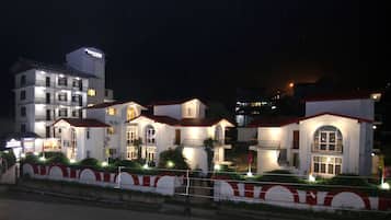Vista frontal de la propiedad por la tarde o noche