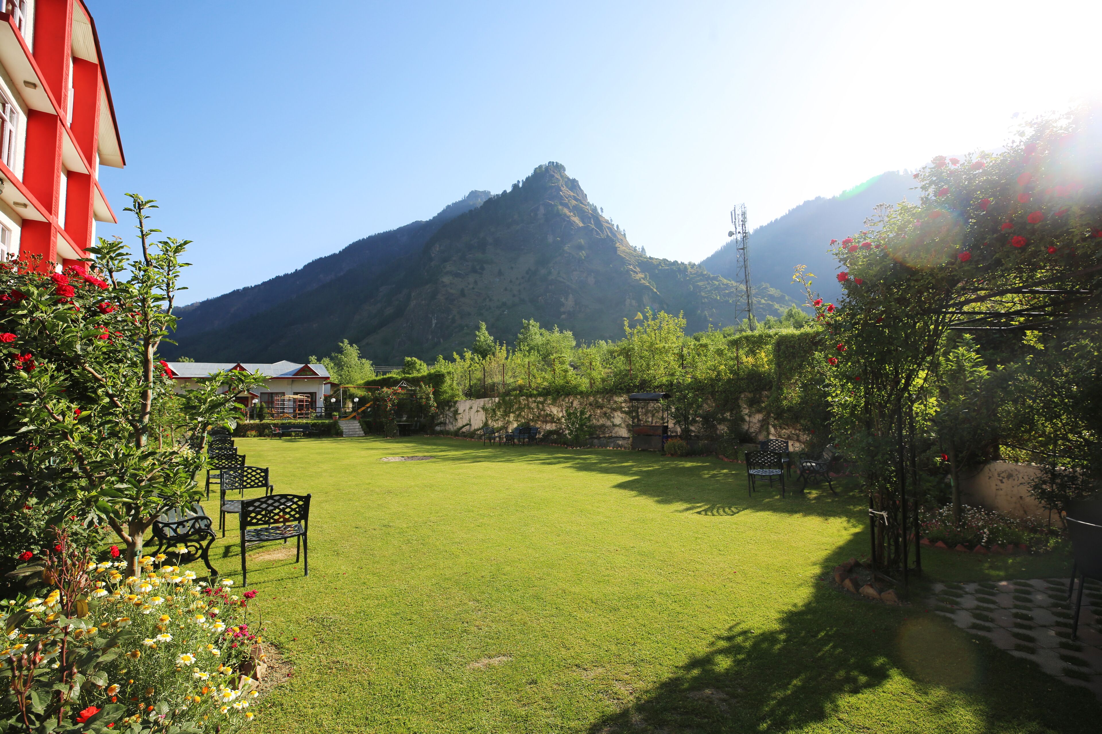 Un giardino curato con prato, area relax e vista sulle montagne.