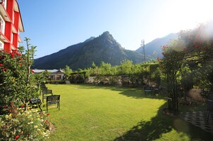 Un giardino curato con prato, area relax e vista sulle montagne.