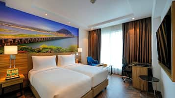 Une chambre d’hôtel avec un grand lit, un bureau, une chaise et une vue sur une rivière et un pont.