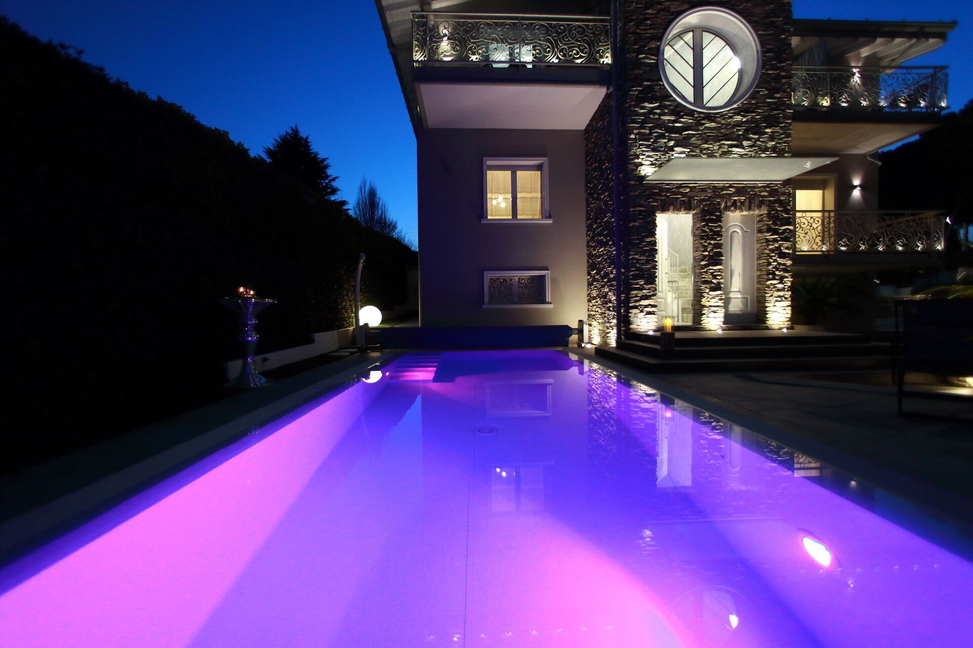 Una casa moderna con piscina al anochecer.