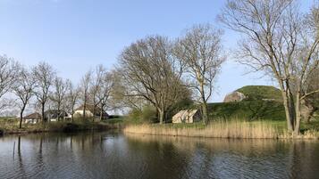 A calm river with trees and houses on the banks.