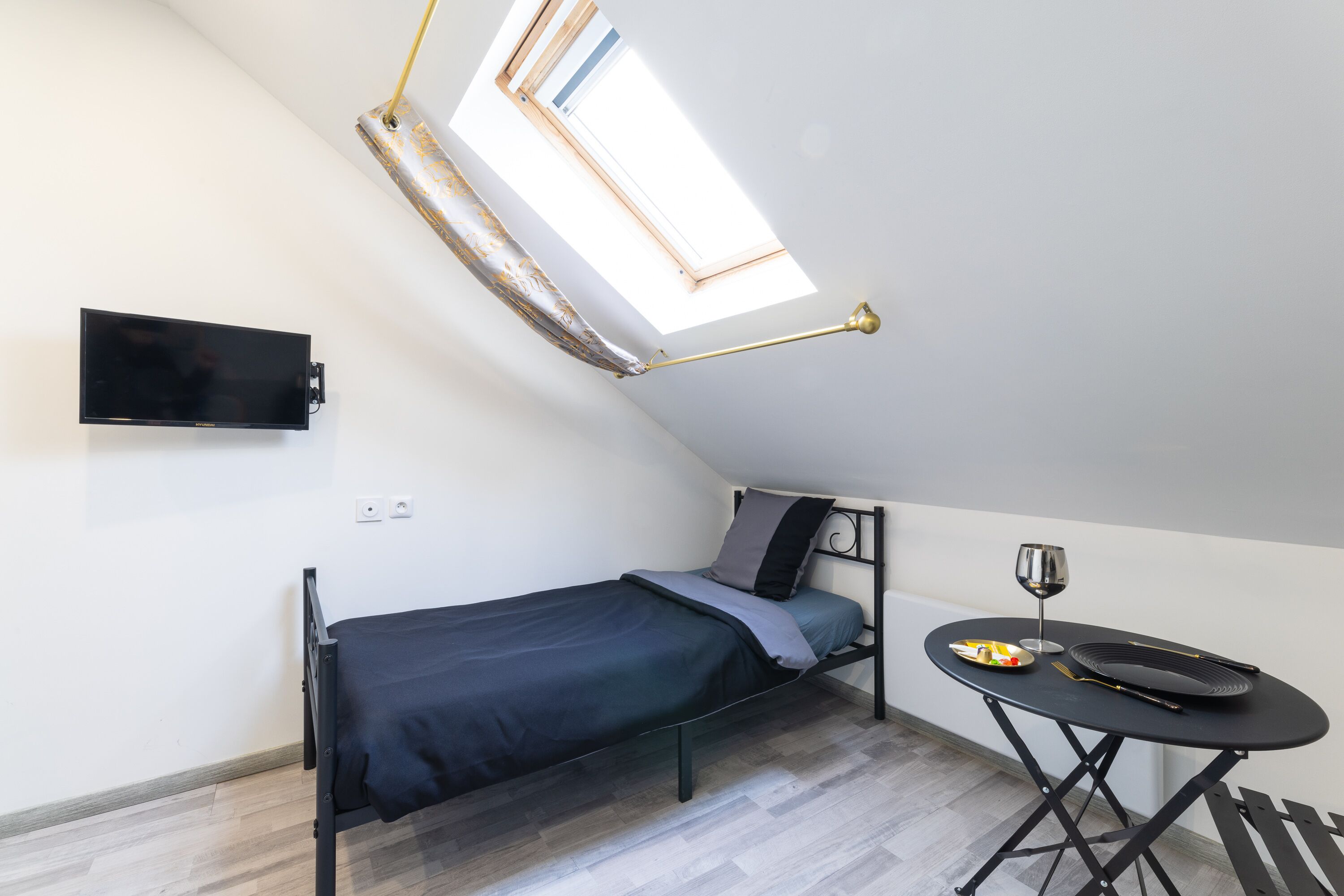 Une petite chambre moderne, équipée d’un lit, d’un bureau et d’une table à manger.