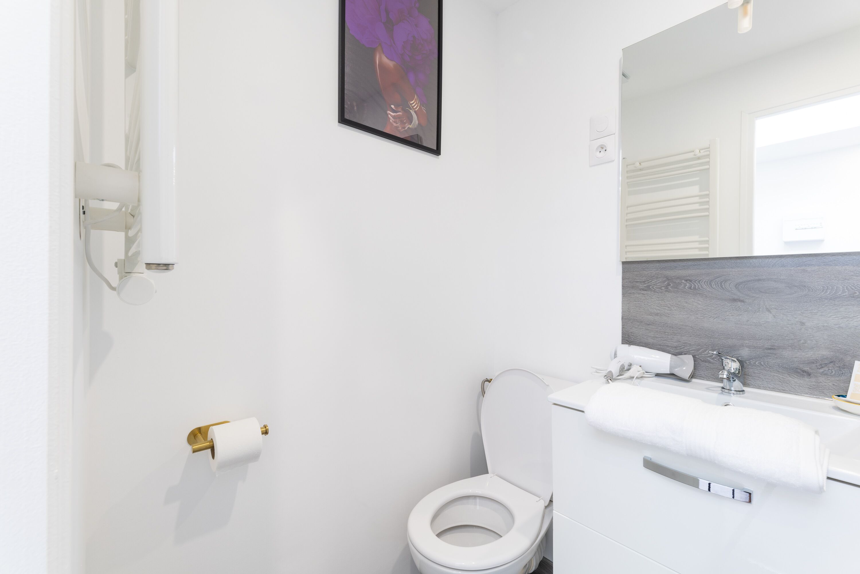 Ein modernes Badezimmer mit Toilette, Waschbecken und Spiegel.