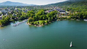 Une vue sur le lac, avec un quai, des bateaux et une petite île abritant des bâtiments.