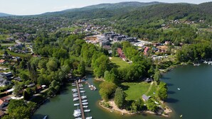 An aerial view of a lakeside town with a marina, residential buildings, and surrounding greenery. - Apartamenty Sun & Snow Żeglarska (gmina Lodygowice)