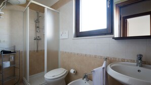 Un bany amb dutxa, vàter, bidet i rentapel.