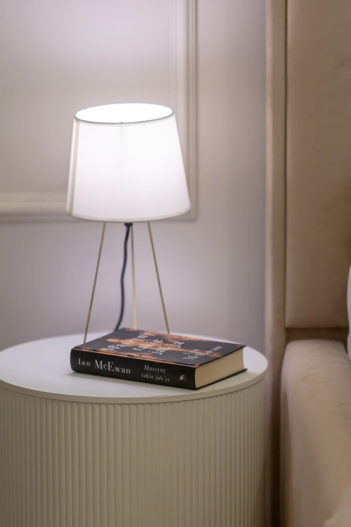 Une table de chevet avec une lampe et un livre.