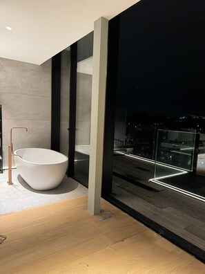 Luxury Apartment | Bathroom | Separate tub and shower, rainfall showerhead, hair dryer, slippers