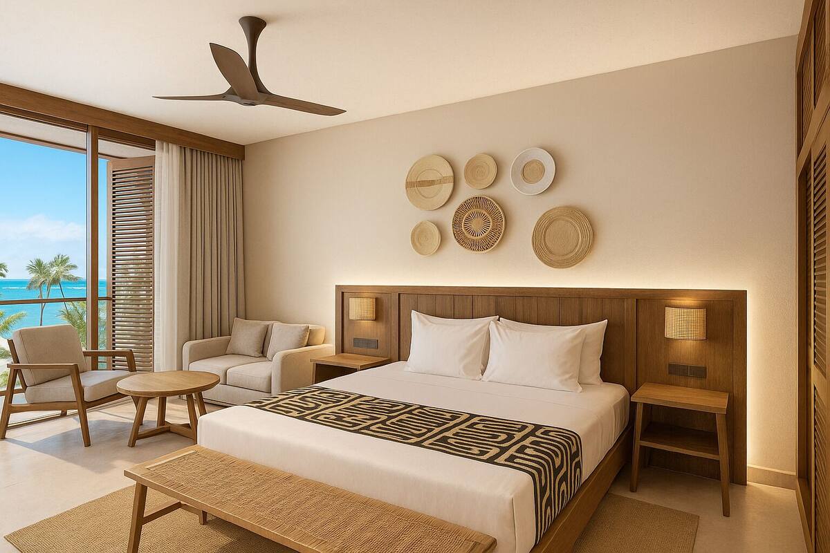 A modern hotel room with a large bed, two bedside tables, a sofa, a chair, and a view of the ocean.