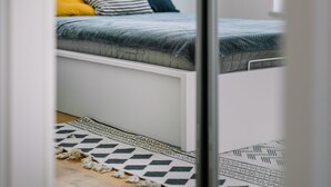 A room with a bed, a window, and a patterned rug. - RentPlanet - Świętego Mikołaja (Wroclaw)