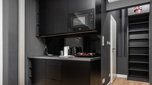 A compact kitchen with a microwave, coffee maker, and toaster. - Smart Apartments- Old Town Train Station (Kraków)