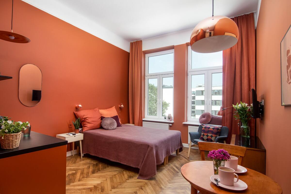 Un dormitorio moderno con una cama grande, un escritorio y un comedor.