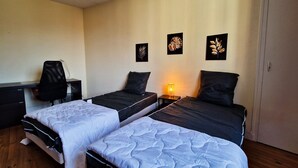 Un dormitorio con dos camas individuales, un escritorio y una silla.