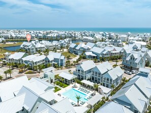 Un quartier résidentiel situé sur la côte, composé de plusieurs maisons à deux étages, d’une piscine et offrant une vue sur l’océan.