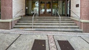 La entrada de un edificio con el número 300, con un acceso por doble puerta y un juego de escalones que conducen a ella.